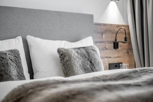 a bedroom with a bed with pillows and a lamp at Bühlhof Appartements in Lech am Arlberg