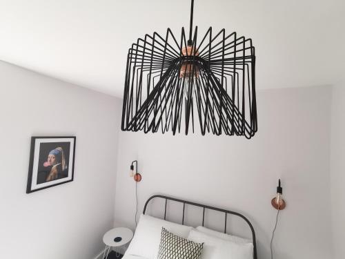 um candelabro pendurado por cima de uma cama num quarto em Richmond Apartments by Switchback Stays em Cardiff