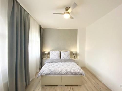 GrandLux Villa & Spa في تبليتسه: غرفة نوم بسرير ومروحة سقف
