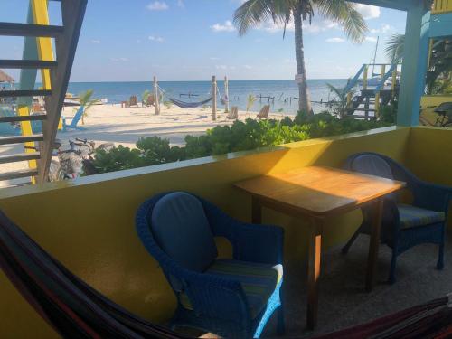 a restaurant with a table and chairs and the beach at Colinda Cabanas in Caye Caulker