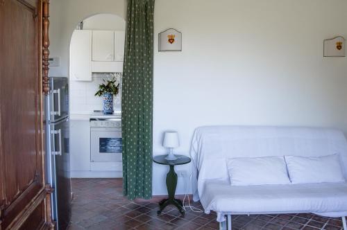 ein Wohnzimmer mit einem Sofa und einer Küche in der Unterkunft Tenuta San Calogero Appartamento Alloro in Agnone Bagni