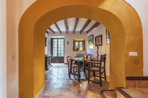 an archway in a dining room with a table and chairs at Son Niu Vell-La Hermossa in Valldemossa