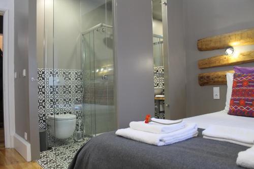 una camera da letto con doccia e un letto con asciugamani di GoodTime Marquês Suites a Lisbona