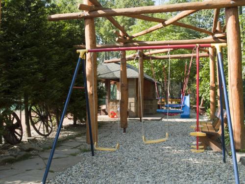 um parque infantil com baloiços e um gazebo em Penzion Na Kamyncu em Jablunkov