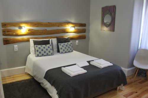 una camera da letto con un letto grande con asciugamani sopra di GoodTime Marquês Suites a Lisbona