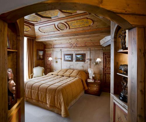 クールシュヴェルにあるAppartements d'Exceptionの木製の天井のベッドルーム1室(大型ベッド1台付)