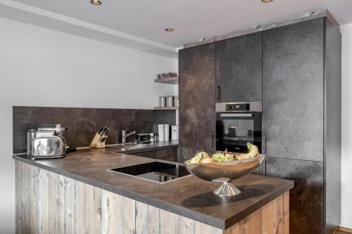 a kitchen with a bowl of fruit on a counter at Bühlhof Appartements in Lech am Arlberg