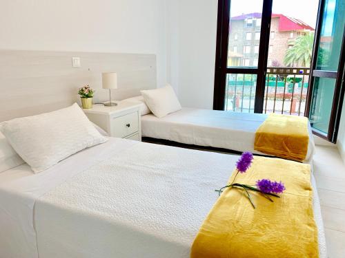 a bedroom with two beds with yellow and white sheets at Apartamento El Socaire Playa Trengandín in Noja