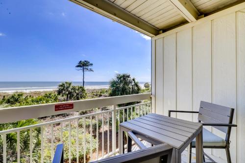 a table and chairs on a balcony with the beach at Breakers 215 in Hilton Head Island
