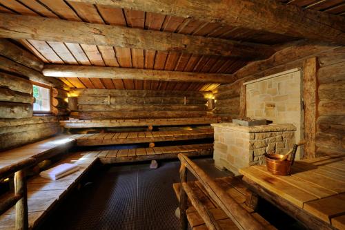an indoor hot tub in a wooden cabin with a stone fireplace at VILA VITA Burghotel Dinklage in Dinklage
