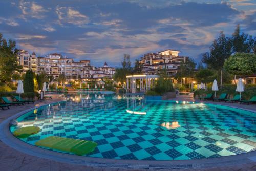 a swimming pool in a resort at night at Poseidon VIP Residence Club Balneo & SPA Resort in Nesebar