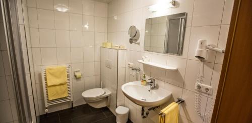 a white bathroom with a toilet and a sink at Haus Annette in Schröcken