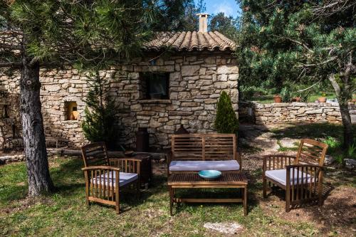 a table and chairs in front of a stone building at Mas de l'Arlequi in Rojals
