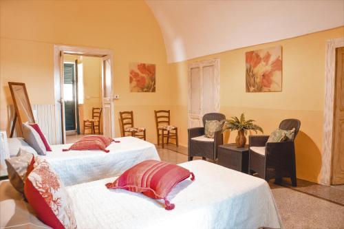 una camera con due letti e sedie in una stanza di Casa Vacanza GICO' ad Alezio