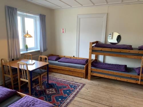 um quarto com beliches, uma mesa e uma sala de jantar em Hohenwarte em Højer