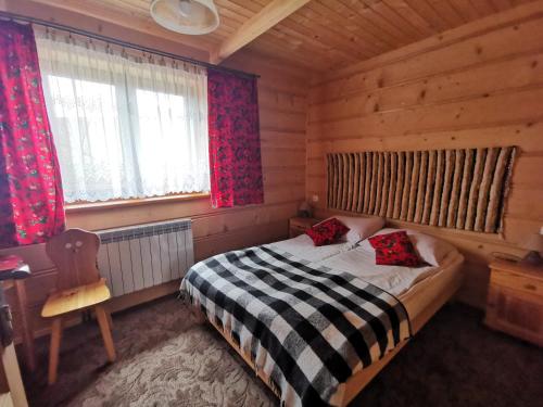 a bedroom with a bed in a wooden cabin at Apartamenty Stasikowa Chata in Białka Tatrzańska