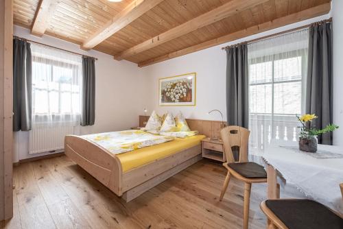 a bedroom with a bed and a table and chairs at Pineiderhof in Funes