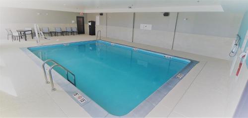 a large swimming pool with blue water in a room at avid hotels - Lancaster by IHG in Lancaster