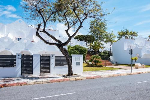 a tree on a sidewalk next to a street at VIME La Reserva de Marbella in Marbella