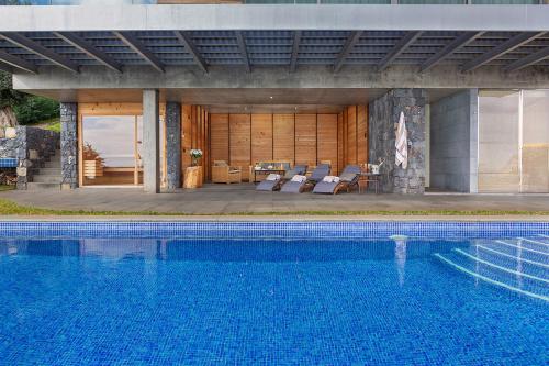 a swimming pool with chairs and a house at Fazendinha by Real Vision in Gaula