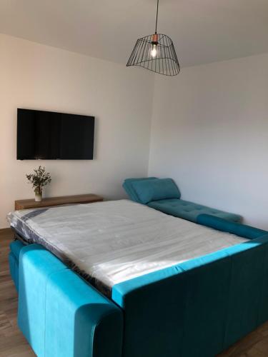 une chambre avec un lit bleu et une télévision à écran plat dans l'établissement Spacieux studio entièrement rénové, à Ajaccio