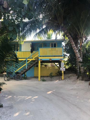a small house with a yellow and blue house at Colinda Cabanas in Caye Caulker
