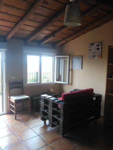 a room with a table and a chair and windows at An'Ca' La Pura in Villanueva del Conde