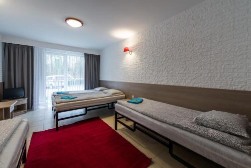 a hospital room with two beds and a red rug at Ośrodek Wypoczynkowy Gwarek Mazury in Giżycko