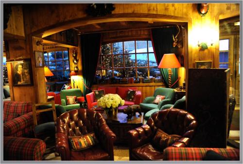 a living room with chairs and a table with flowers at Hôtel Saint-Georges in Megève