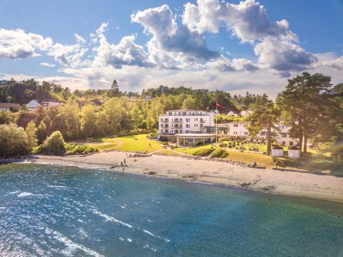 an aerial view of a beach with a white house at Strand Hotel Fevik - by Classic Norway Hotels in Fevik