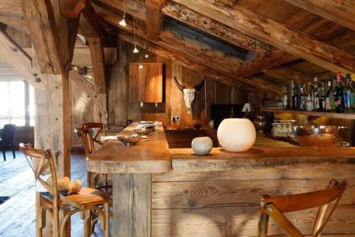 a bar in a room with wooden walls and chairs at Chalet Javen - 520m2 avec piscine chauffée et home cinéma in Megève