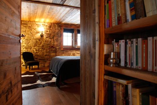 a bedroom with a bed and a book shelf with books at Chalet Javen - 520m2 avec piscine chauffée et home cinéma in Megève