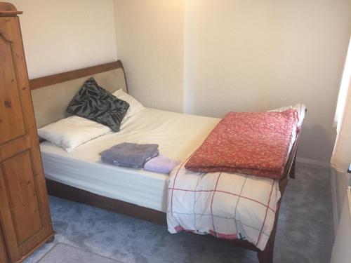 un piccolo letto con due cuscini sopra in una stanza di Beautiful Home Near Worcester Royal Hospital a Hindlip