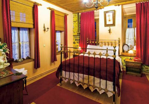 - une chambre avec un lit et des rideaux rouges dans l'établissement Siatistino Archontariki, à Siátista