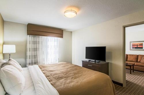 a hotel room with a bed and a flat screen tv at Sleep Inn & Suites West-Near Medical Center in Rochester