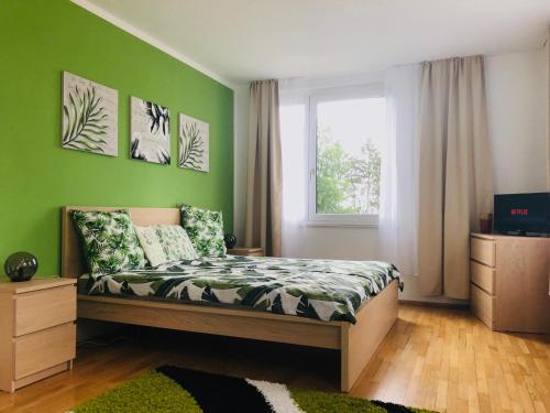 Un dormitorio con una cama con paredes verdes y una ventana en Haus Graf Velden en Velden am Wörthersee