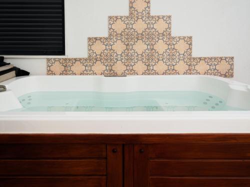 y baño con bañera y una cruz en la pared. en Atico Aligma, en Granada