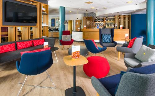 a waiting area with couches and chairs in a store at Holiday Inn Express Burton on Trent by IHG in Burton upon Trent