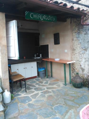 a table and a chair in a room with a stone wall at An'Ca' La Pura in Villanueva del Conde