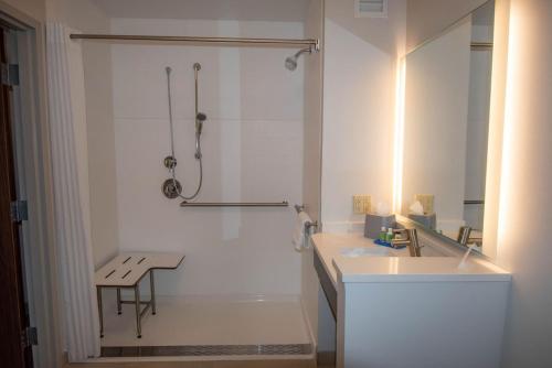 baño blanco con ducha y lavamanos en Holiday Inn Express & Suites Tonawanda - Buffalo Area, an IHG Hotel en Tonawanda