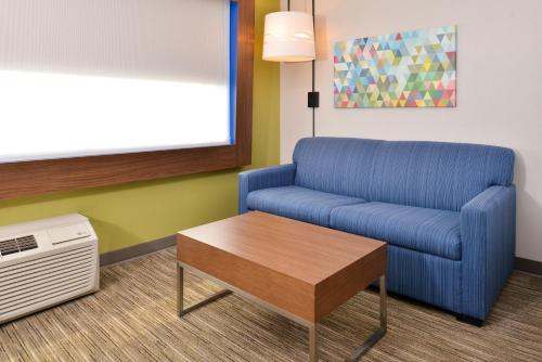 a living room with a blue chair and a table at Holiday Inn Express - Early, an IHG Hotel in Early