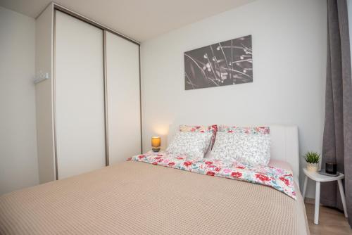 ein Schlafzimmer mit einem großen Bett mit weißen Wänden in der Unterkunft Apartament Malūno in Palanga