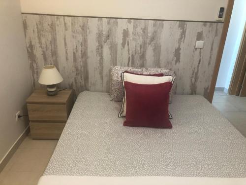 een slaapkamer met een bed met een rood kussen erop bij Bayview Apartment 106 in Albufeira