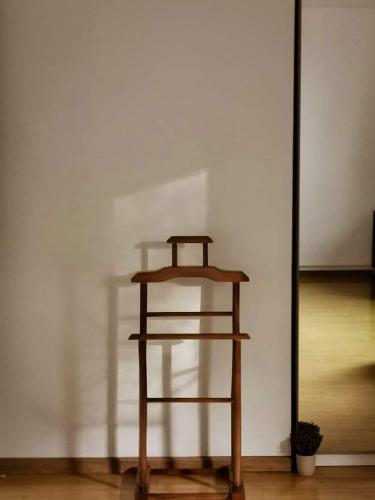 a wooden shelf sitting next to a white wall at Casa File de Poveste in Târgu Jiu