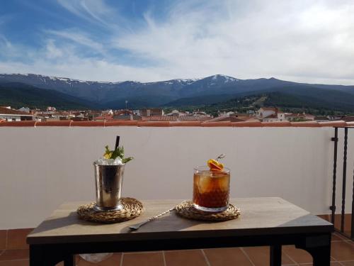 una mesa con 2 bebidas en la parte superior de un balcón en Hotel El Picón de Sierra Nevada en Jerez del Marquesado