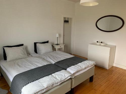 a bedroom with a bed with a mirror on the wall at Villa Västanede in Västanede
