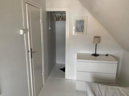 a white room with a staircase and a white dresser at Villa Västanede in Västanede