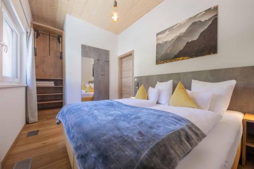 a bedroom with a large bed with a blue blanket on it at Appartement Medraz in Fulpmes