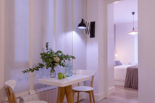 een witte kamer met een tafel en stoelen en een bed bij FerAla Suites Centro A in Granada