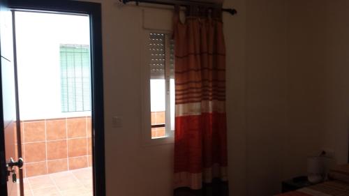 baño con ventana y cortina de ducha en Pension Gran Plaza, en Sevilla